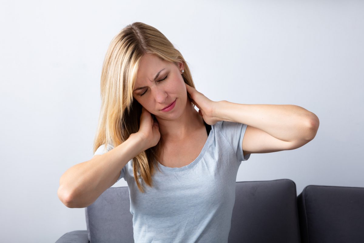 Young Woman Suffering From Neck Pain At Home
